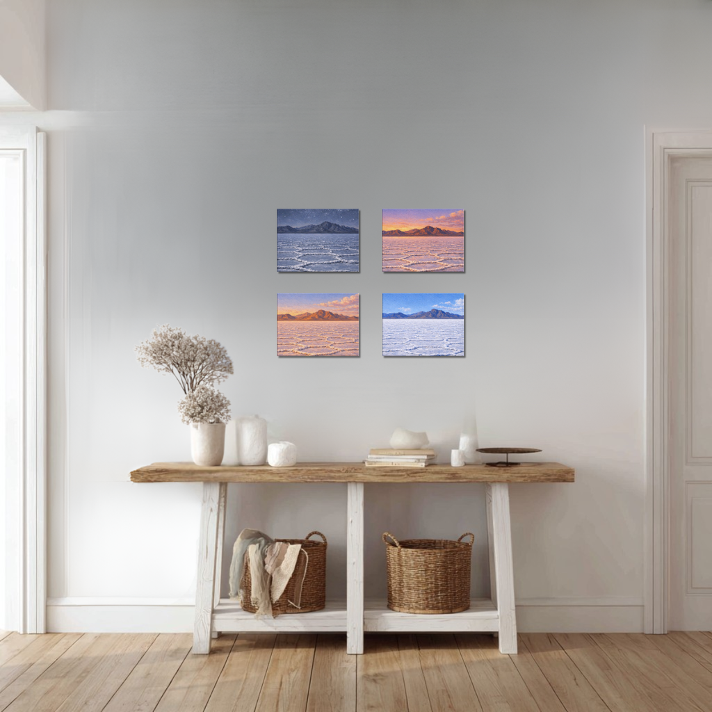 Four landscape paintings of Bonneville Salt Flats at different times of day above a wooden console table in a room with light gray walls and wooden flooring.