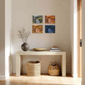 Decorative setup with a table, vases, and four canvas wall art each one depicting a different time of day.