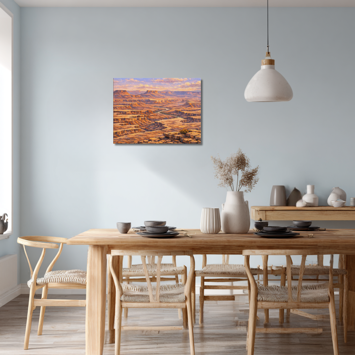 Canvas wall art of Canyonlands National Park at sunrise displayed on the wall of a modern dining room, above a minimalist dining table with warm wood accents, soft natural lighting, and clean contemporary décor.