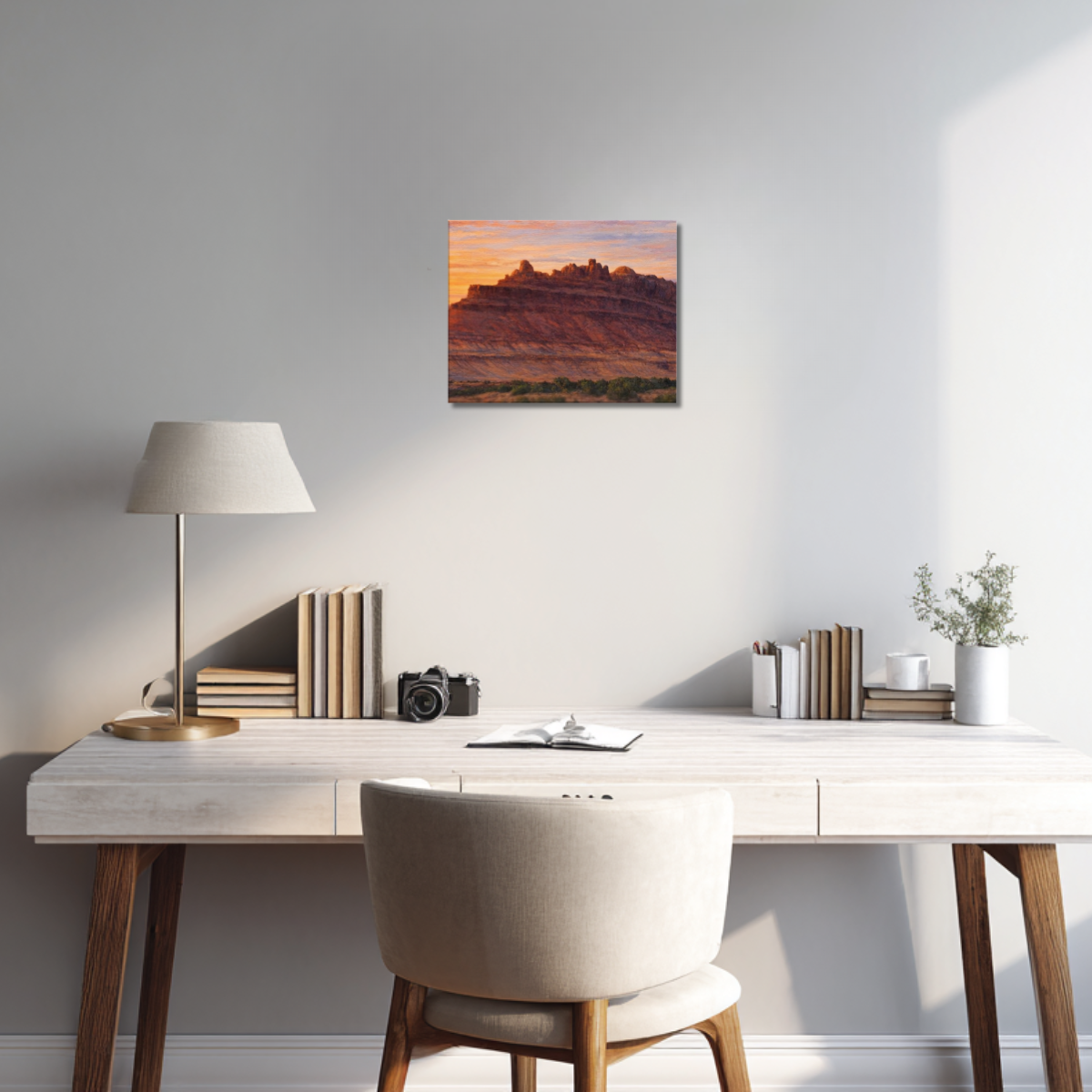 Framed canvas print of the Rock Ship formation during sunset at Black Dragon Canyon hanging on the wall of a modern study, above a clean workspace with a minimalist desk, warm wood accents, and soft natural lighting.